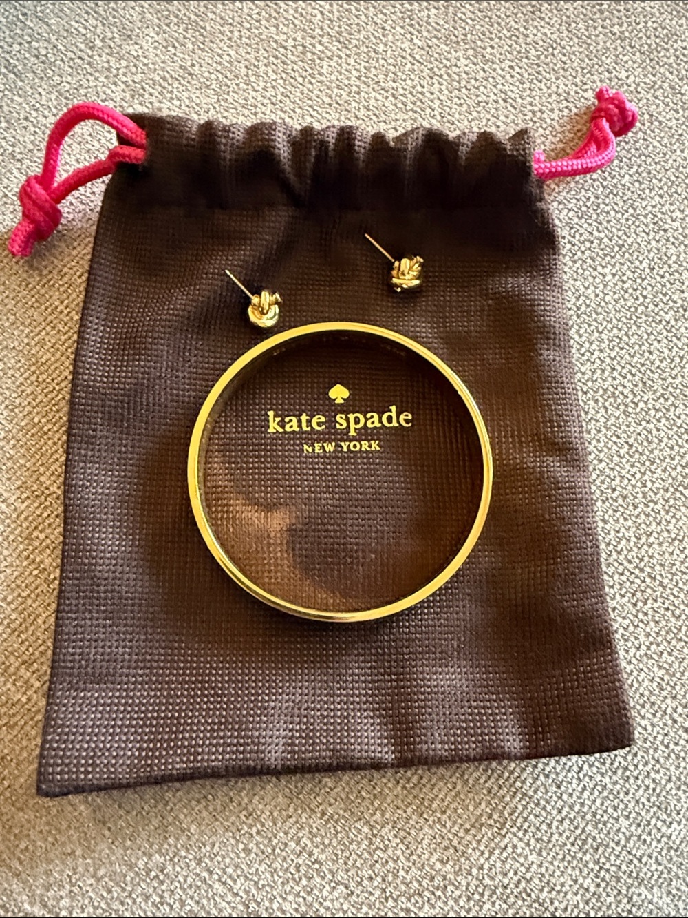 kate spade gold-tone bangle with knot stud earrings. Set together.